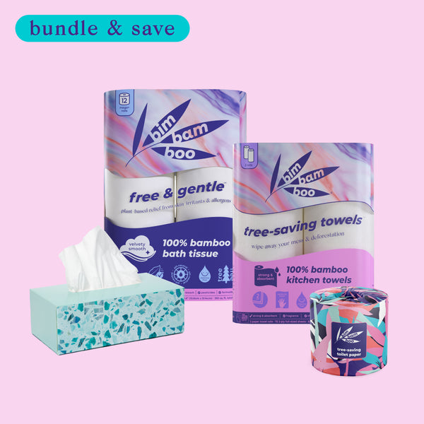 Bundle of bamboo tissue products including bath tissue, kitchen towels, and toilet paper against a pink background.