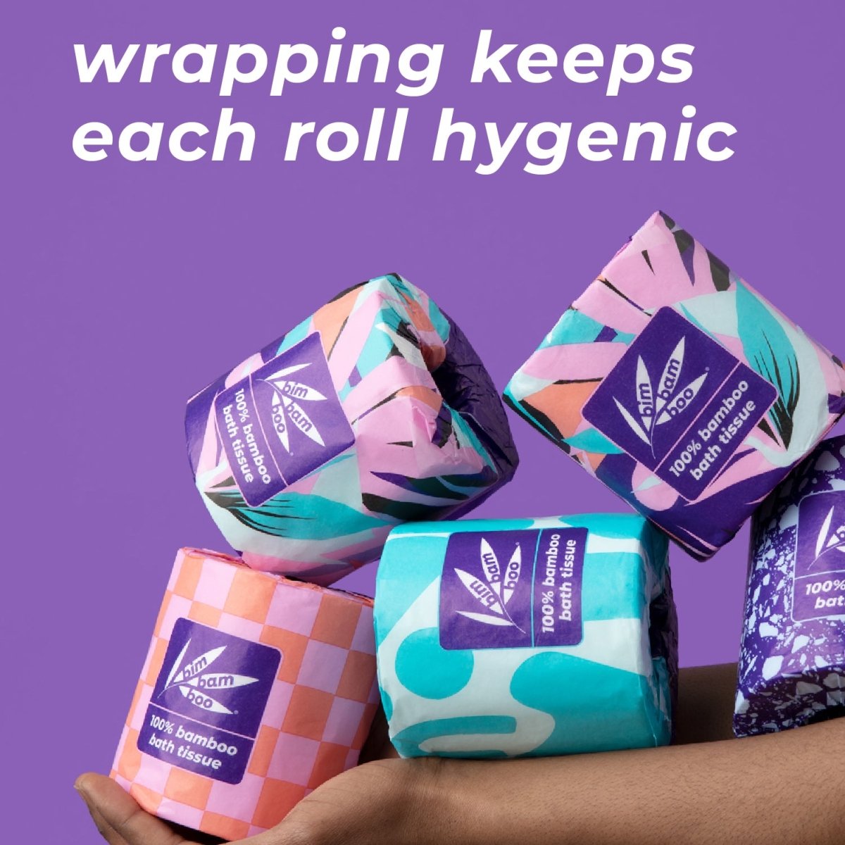 Colorful wrapped toilet paper rolls with text: 'wrapping keeps each roll hygienic'