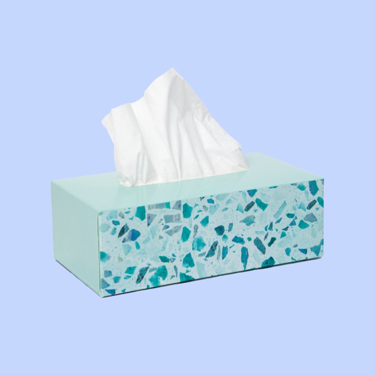 Decorative teal terrazzo tissue box with white tissues on a light blue background