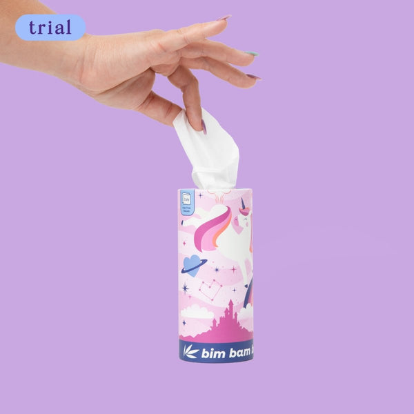 Hand pulling tissue from colorful container against purple background