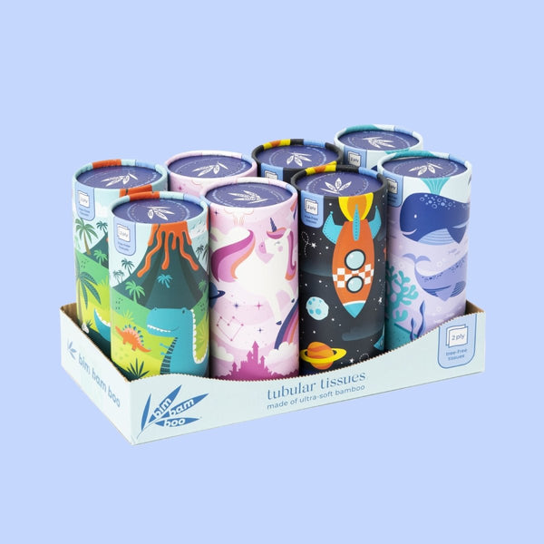 Colorful cylindrical tissue boxes with varied designs including a volcano, whales, a unicorn, and rocket.