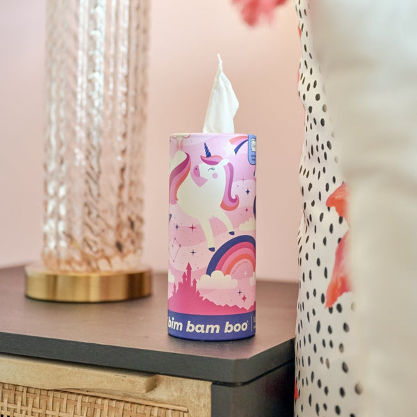 Colorful cylindrical tissue container with unicorn design on a table