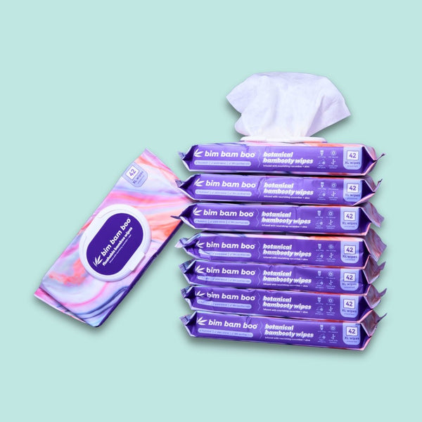 Multiple packages of flushable bamboo wet wipes on a light green background